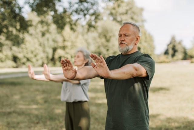 Couple seniors faisant du tai-chi dans un parc